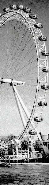 A large Ferris wheel with gondolas in motion against a cloudy sky.