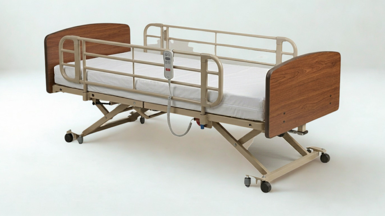 Hospital bed with wooden head and footboards, side railings, a white mattress, wheels, and a remote control hanging from the side.