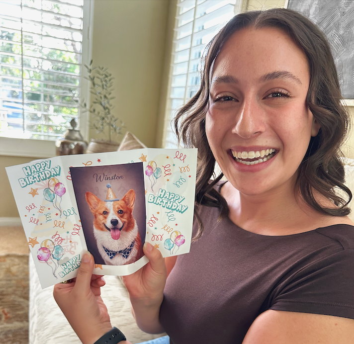 Young lady smiling holding a pet birthday card