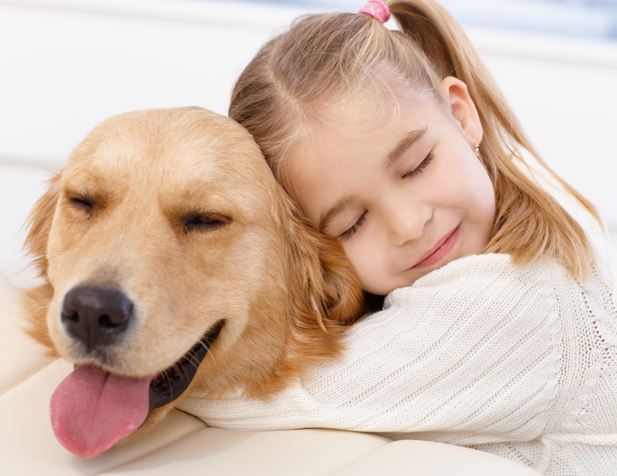 Girl hugging her golden retriever dog