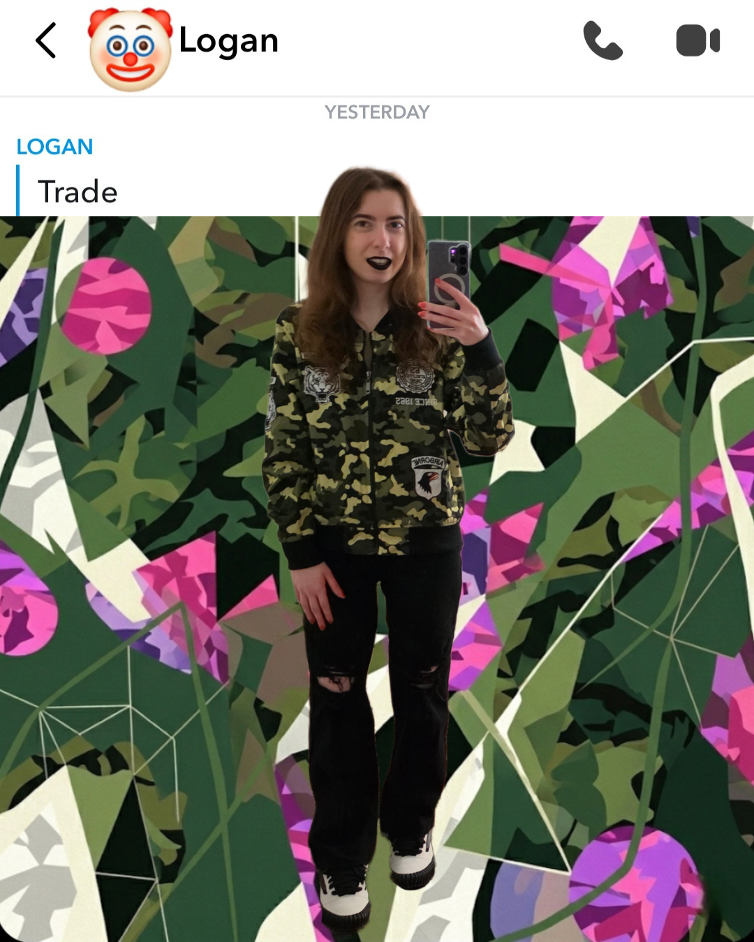 Snapchat DM screenshot of a contact named Logan with a clown emoji sending a one-word text Trade, layered over a photo of a woman in a green camo bomber jacket and ripped black jeans wearing black lipstick against a modern abstract camo background.