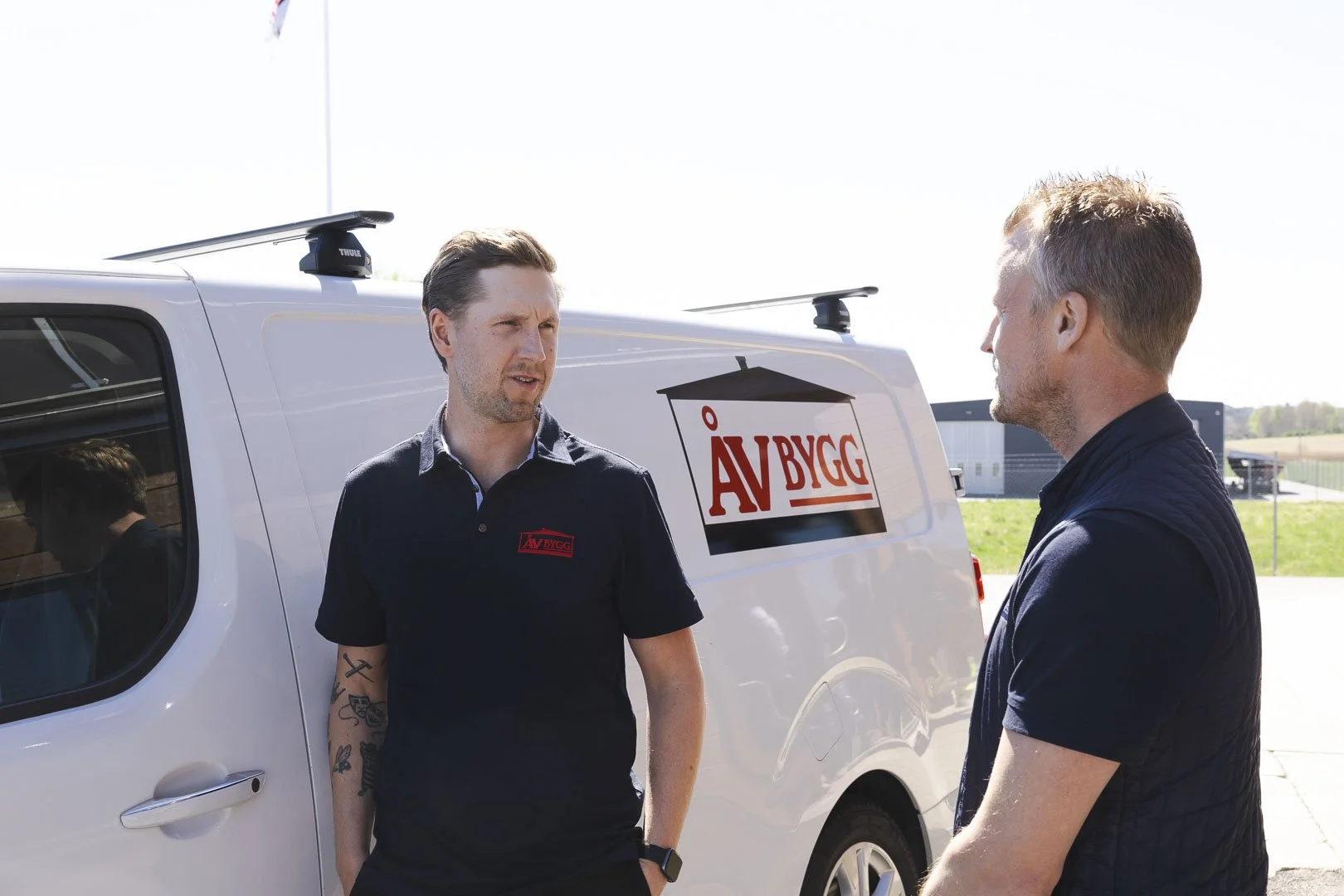 Två medarbetare från ÅV Bygg vid en av företagets servicebilar