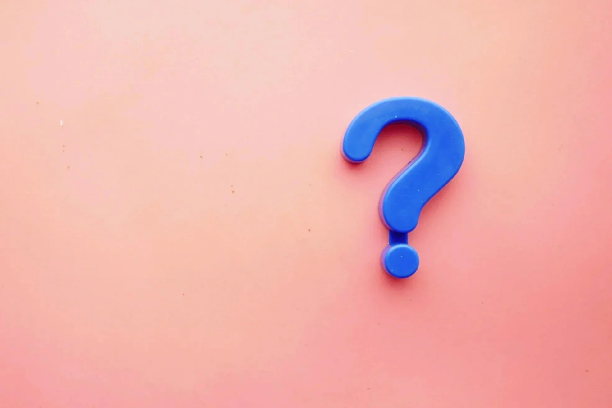 A blue question mark on a pink background.