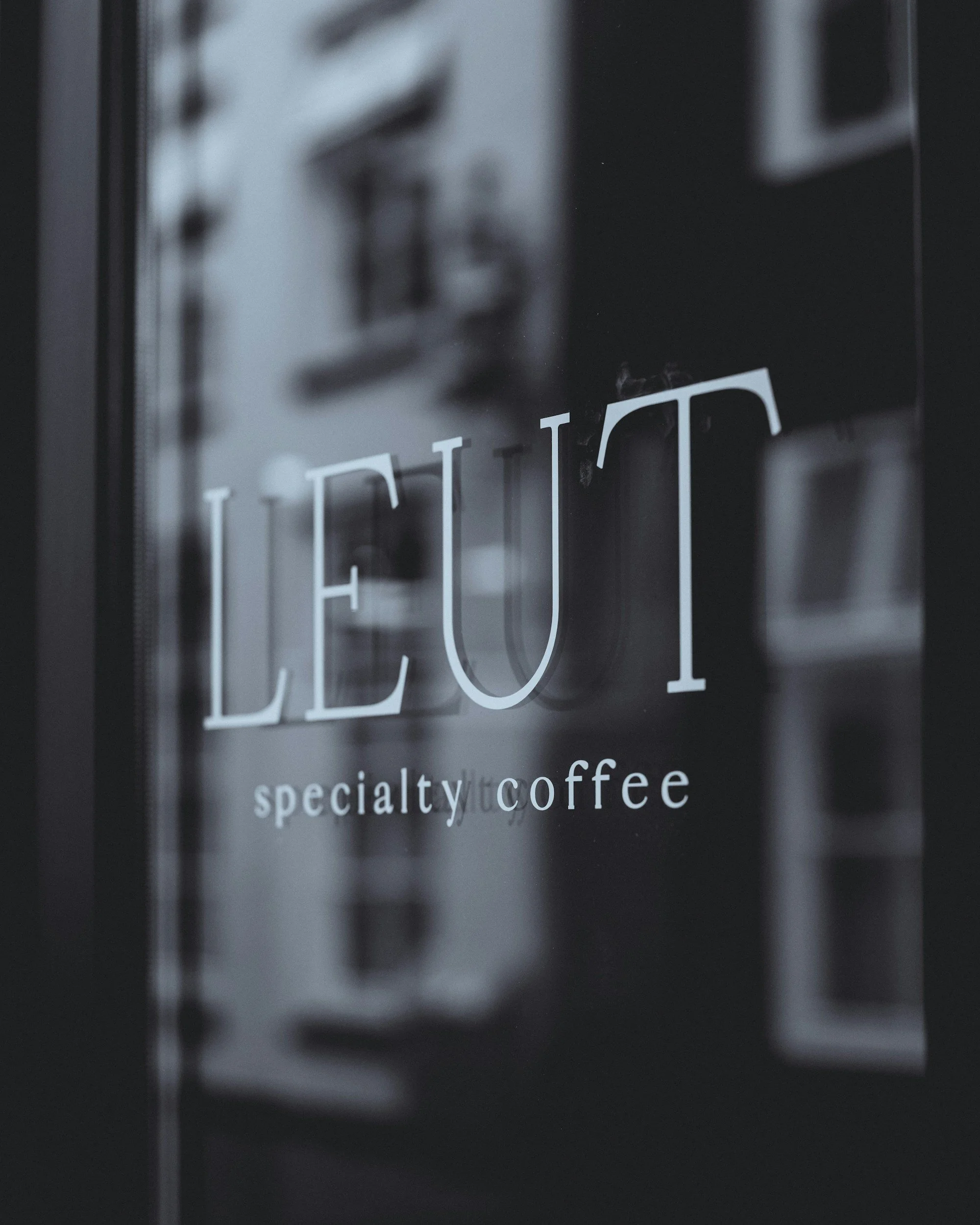 Close-up of a sign for a specialty coffee shop, with part of the sign reading 'CO' and 'specialty coffee' visible underneath.