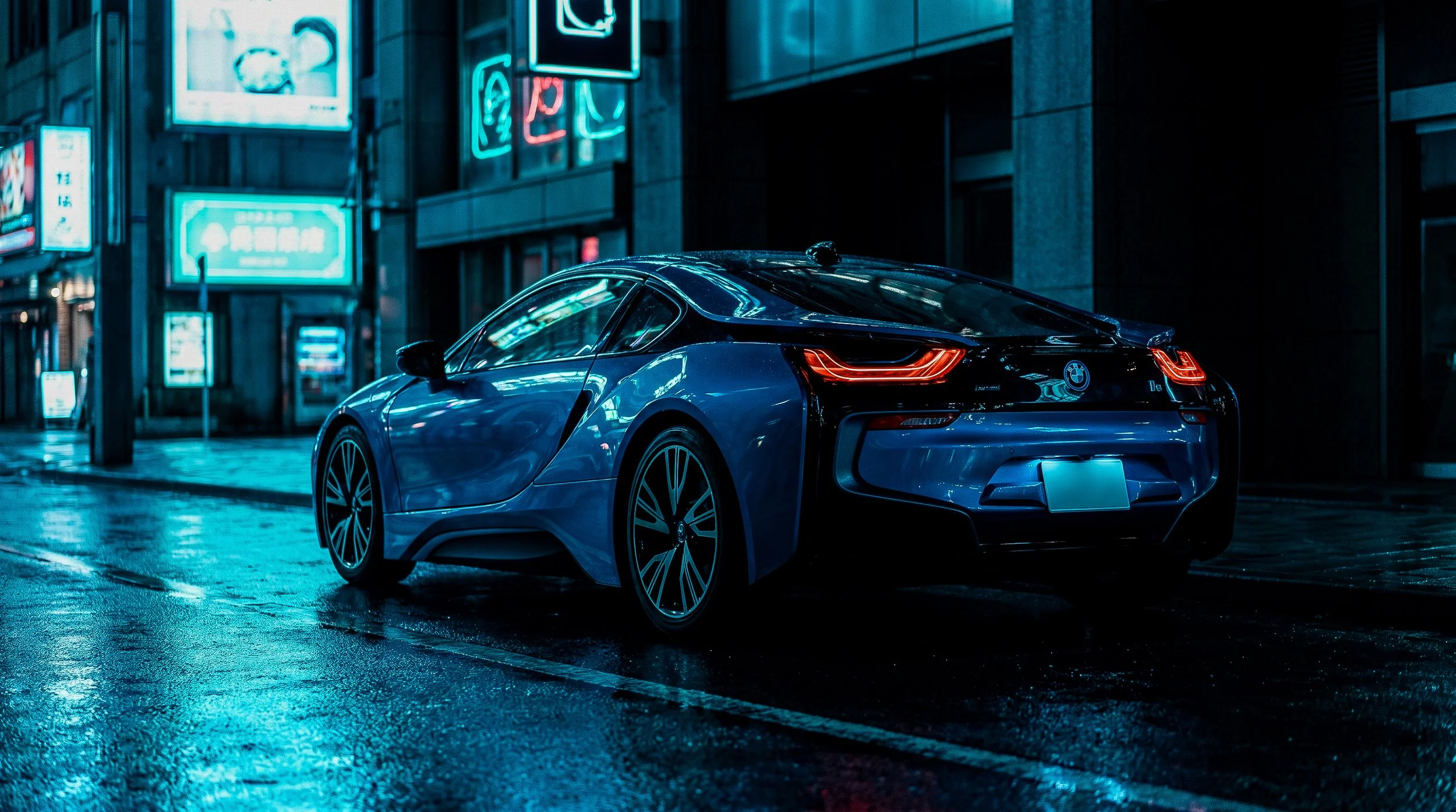 A blue sports car parked on a wet city street at night, illuminated by neon signs reflecting off the pavement.