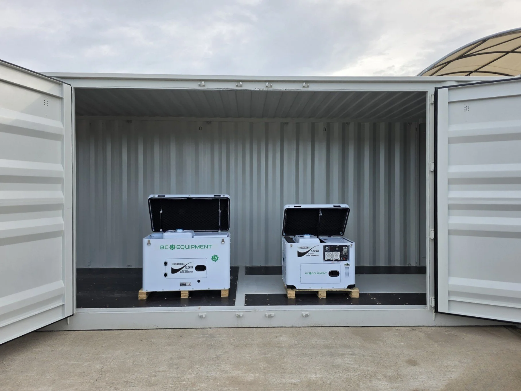 Two portable diesel generators on pallets inside an open storage container