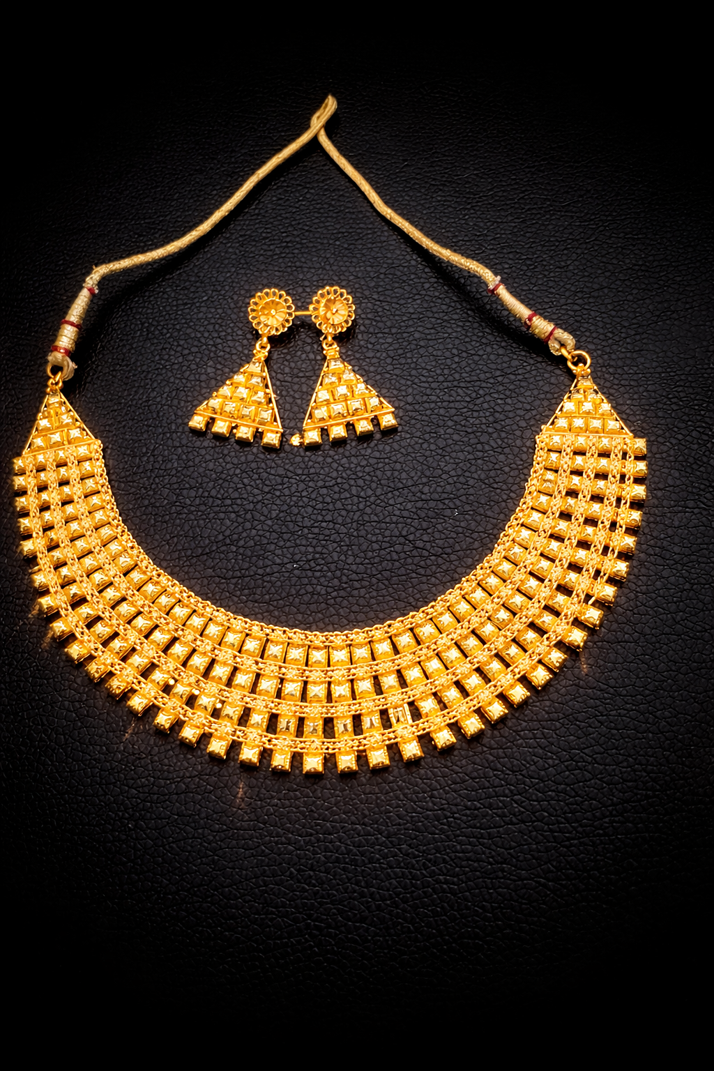 Luxurious gold jewelry set on black.png