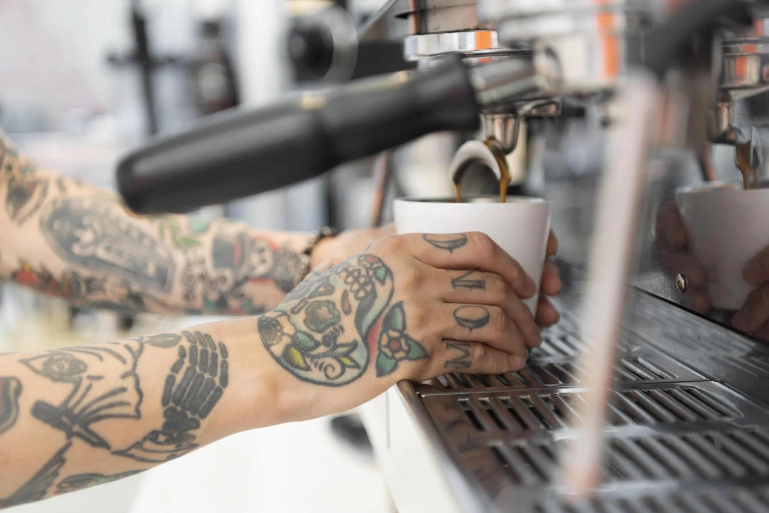 male-barista-with-tattoos-using-coffee-machine-coffee-shop.jpg