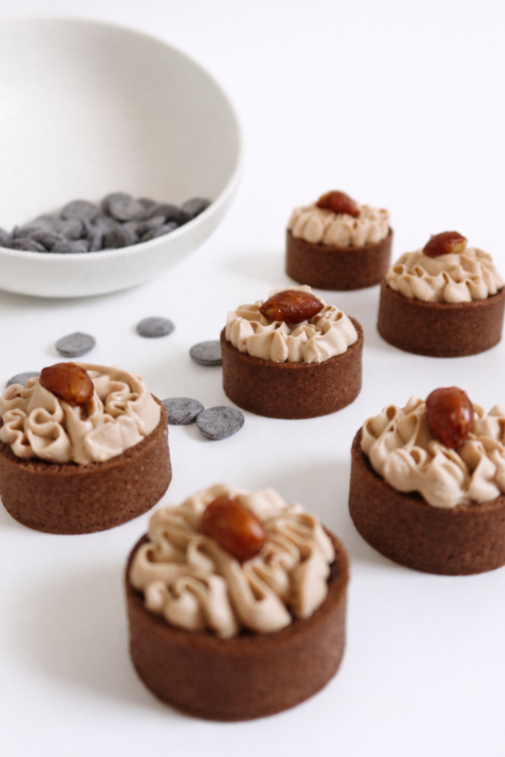 A beautiful spread of peanut banoffee tarts styled with chocolate pieces. Handcrafted mini desserts for parties sydney.
