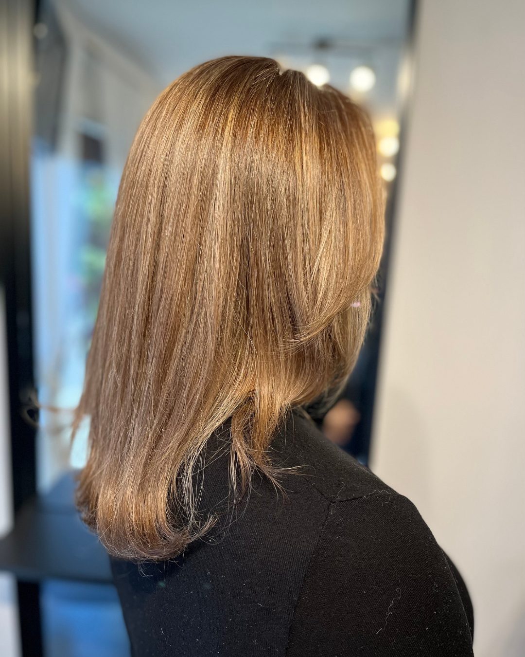 Side view of a woman's shoulder-length, straight, blonde hair.