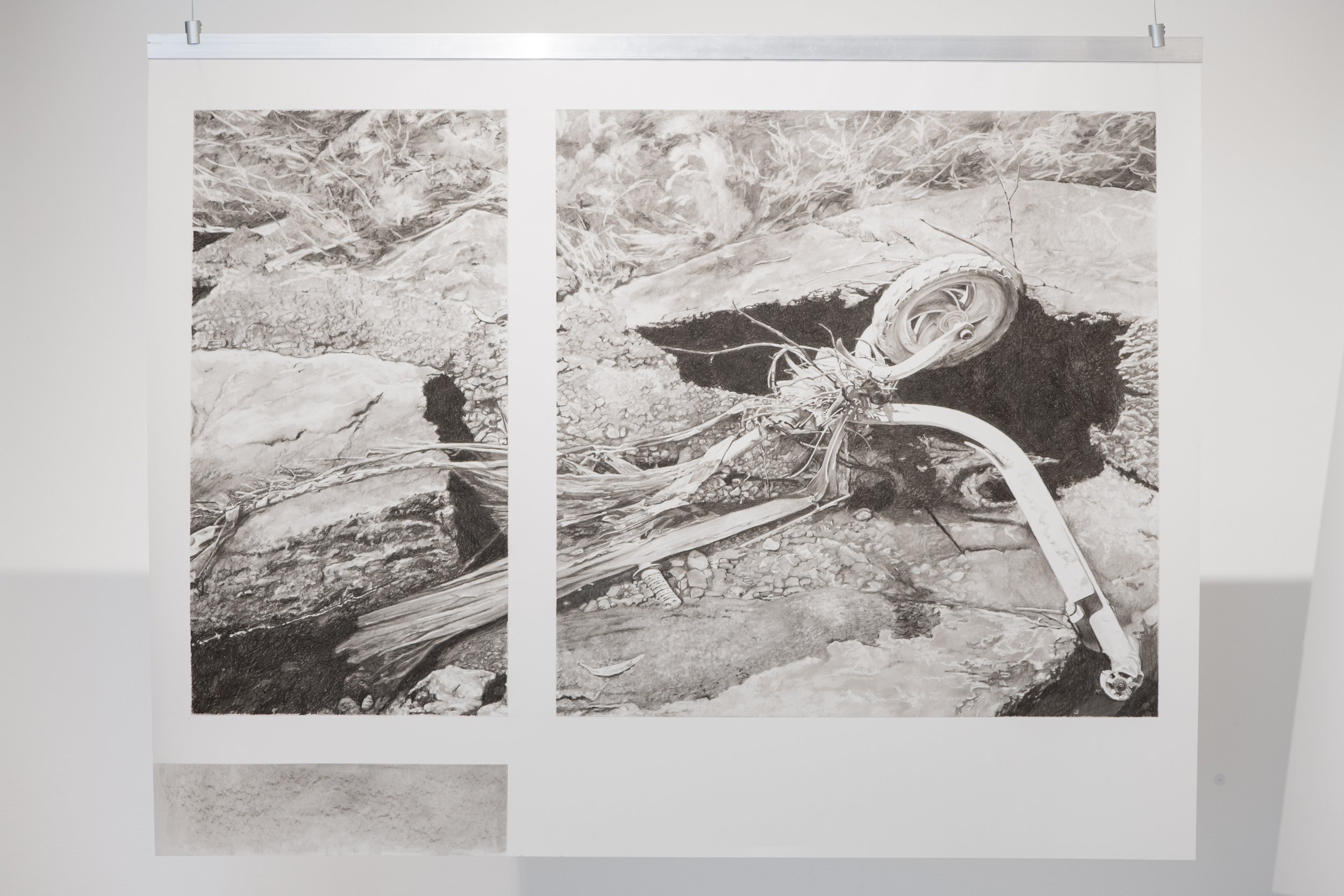 Monochromatic drawing of a discarded childs scooter partially submerged in a rocky, uneven creek bed with soil and small rocks, surrounded by natural landscape.