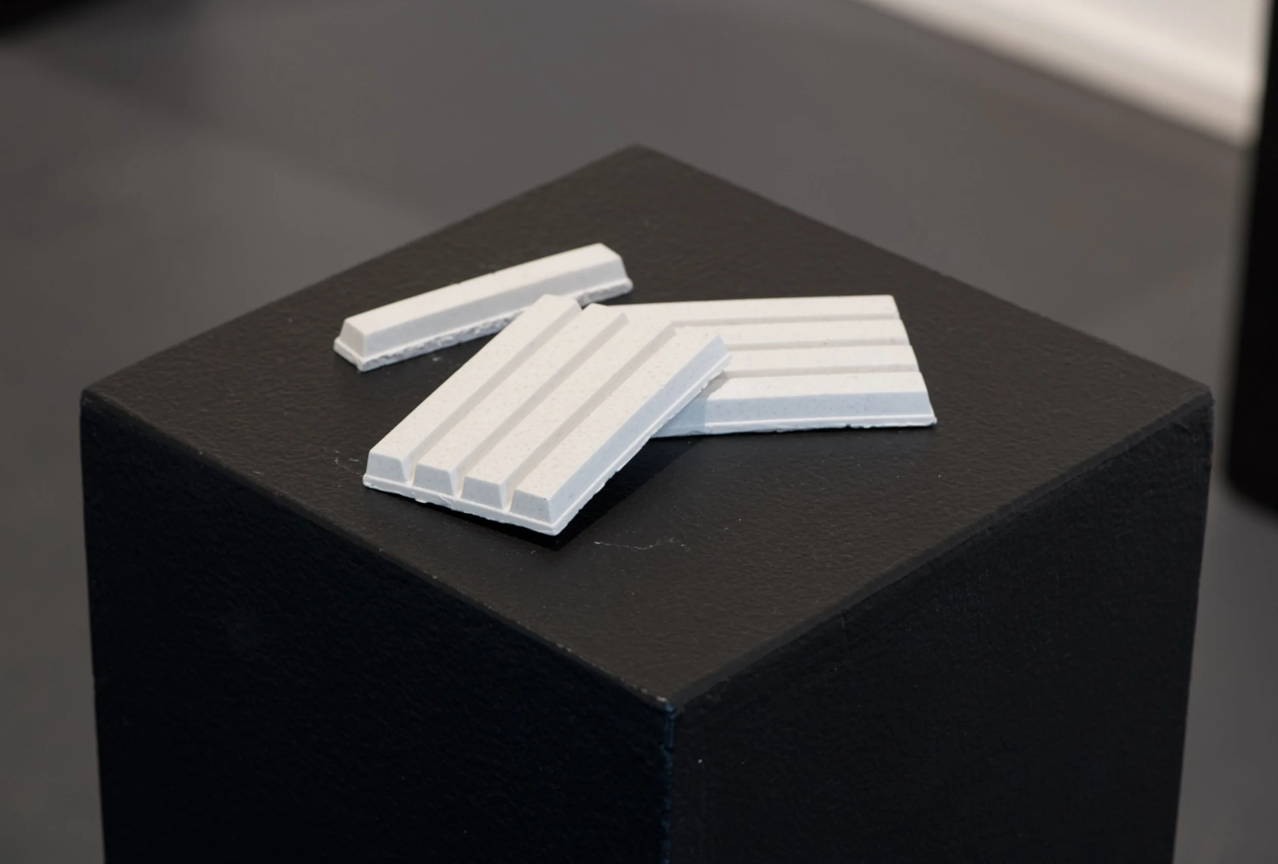 White architectural hydra-stone confectiary on a black stand.