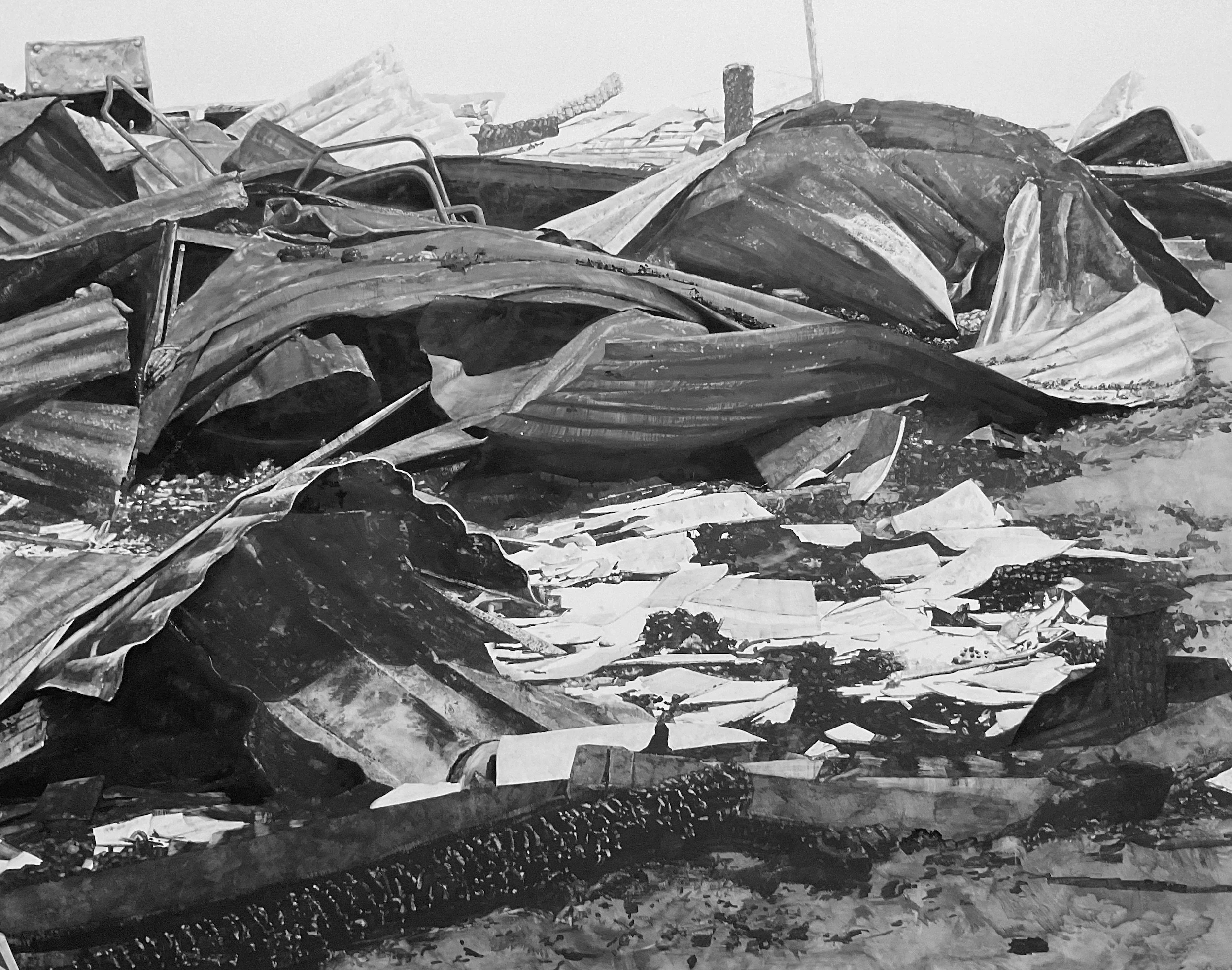 A pile of crumpled, collapsed metal roofing sheets and wreckage, possibly from destroyed buildings, with scattered debris.