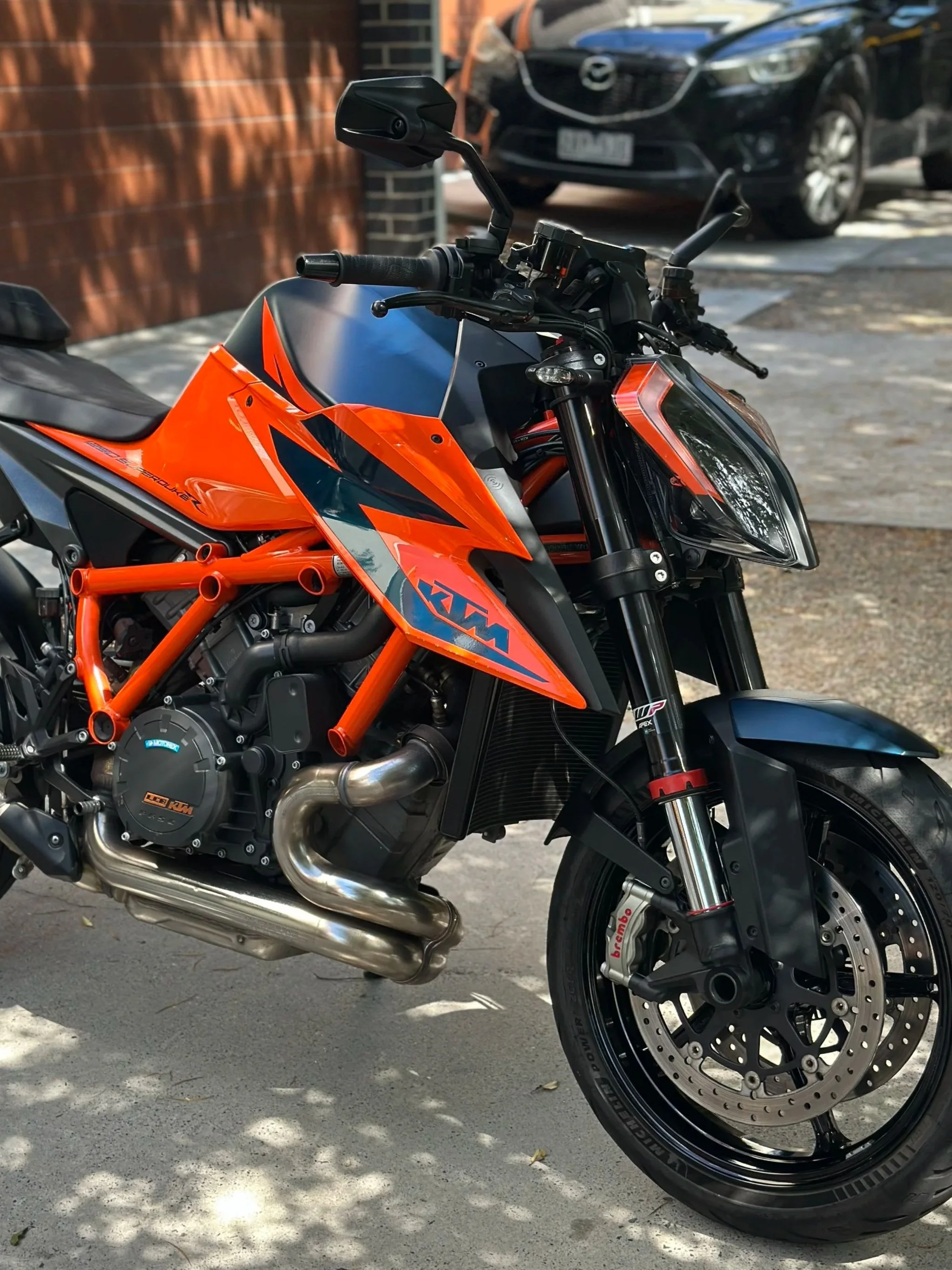 KTM motorcycle parked on a street with black and orange bodywork, a front disc brake, and a black tire.