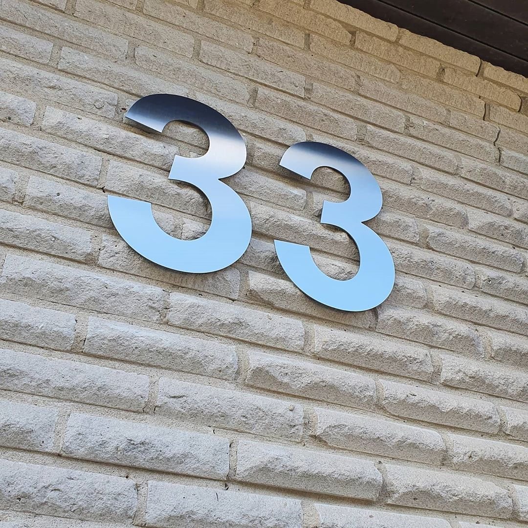 Husnummer 33 i rostfritt stål på natursten