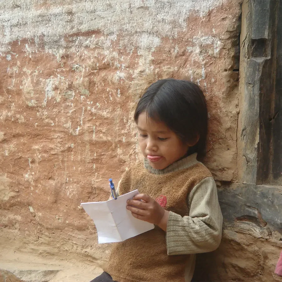 Nepalisches Kind mit Zettel und Stift in der Hand