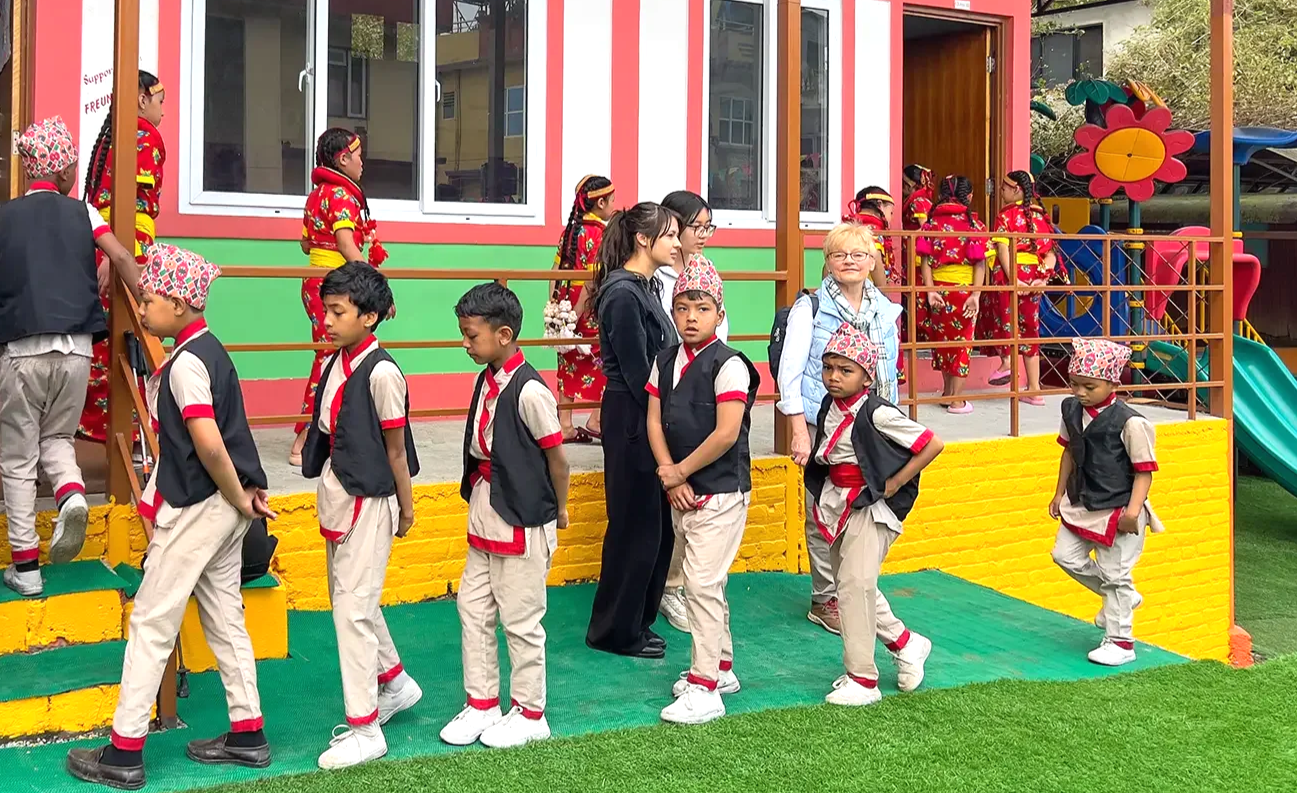 Kinder vor dem neuen Gebäude der Motherland School