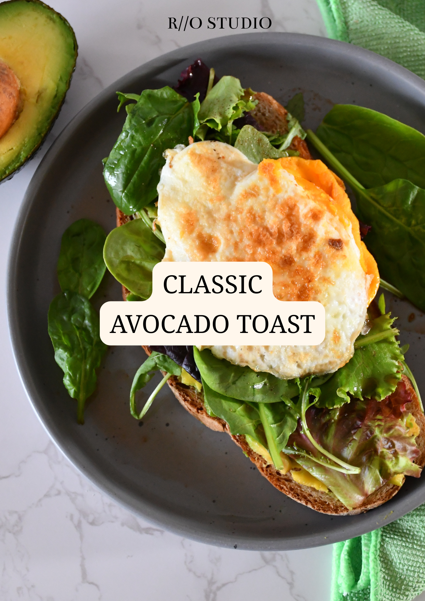 A plate with avocado toast topped with a fried egg and fresh greens, labeled 'Classic Avocado Toast.' An avocado half is partially visible in the background.