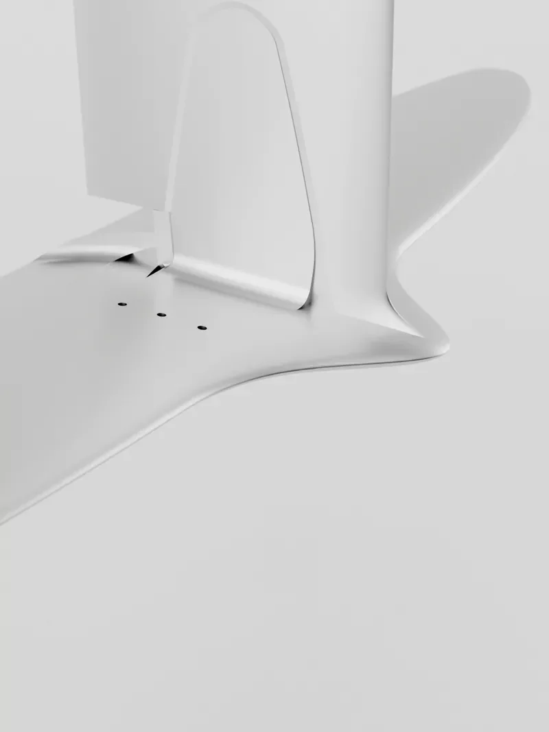 Close-up of the lower back corner of a white computer monitor on a white desk with a shadow cast on the wall behind it.