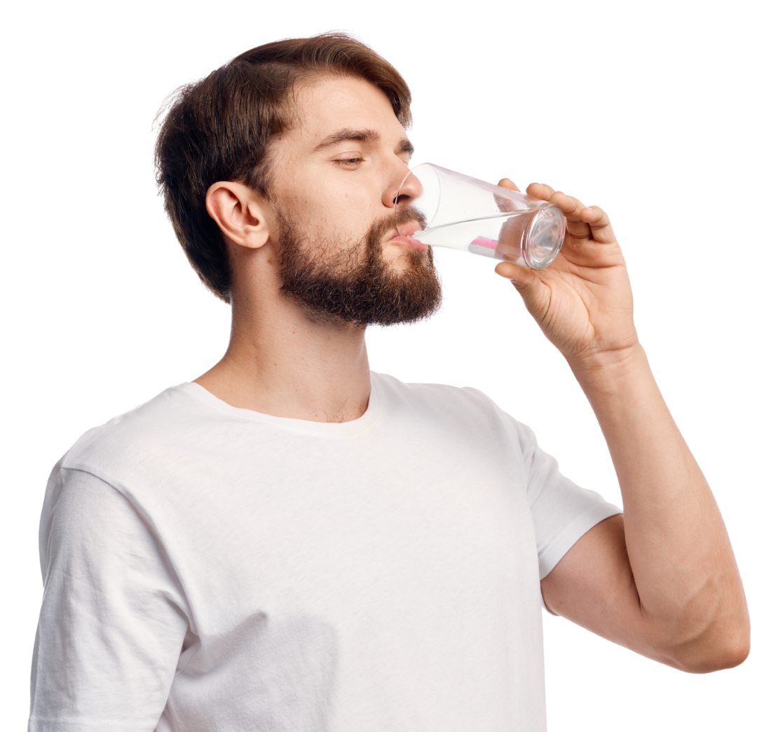 Joven hombre con barba bebiendo agua de un vaso transparente