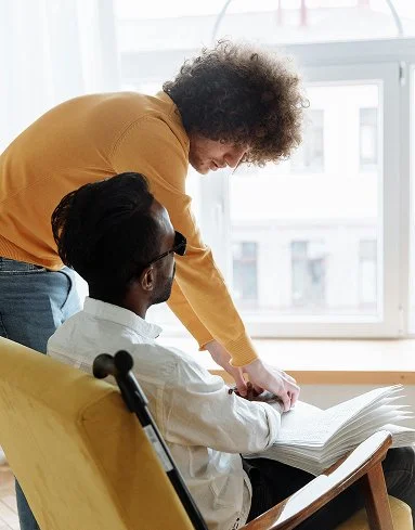 NADSN | National Association of Disabled Staff Networks | Man in Orange Sweater Helping a Blind Man