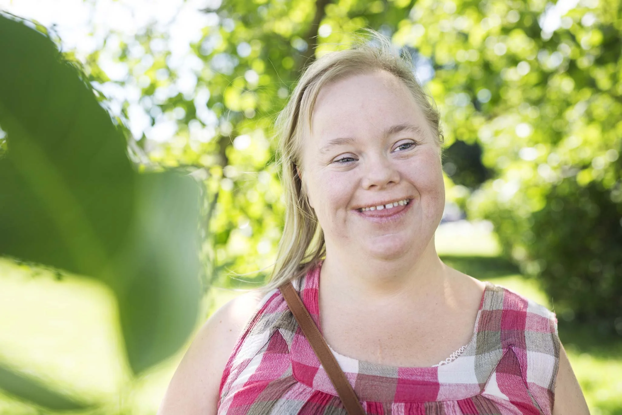 NADSN | National Association of Disabled Staff Networks | A Girl With Down Syndrome Wearing a Pink Dress Smiling
