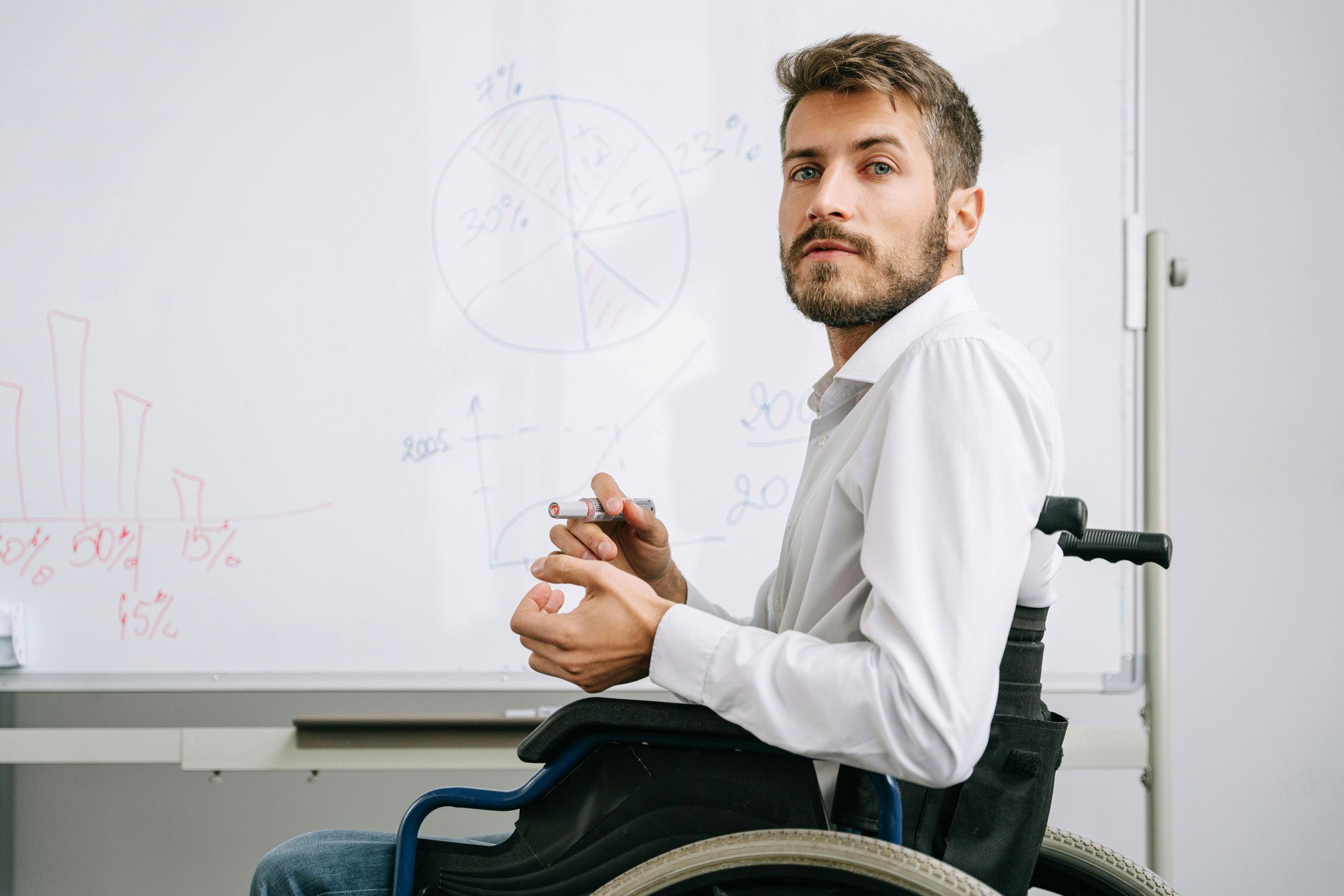 NADSN | National Association of Disabled Staff Networks | Male Teacher in Wheelchair Using a Whiteboard 
