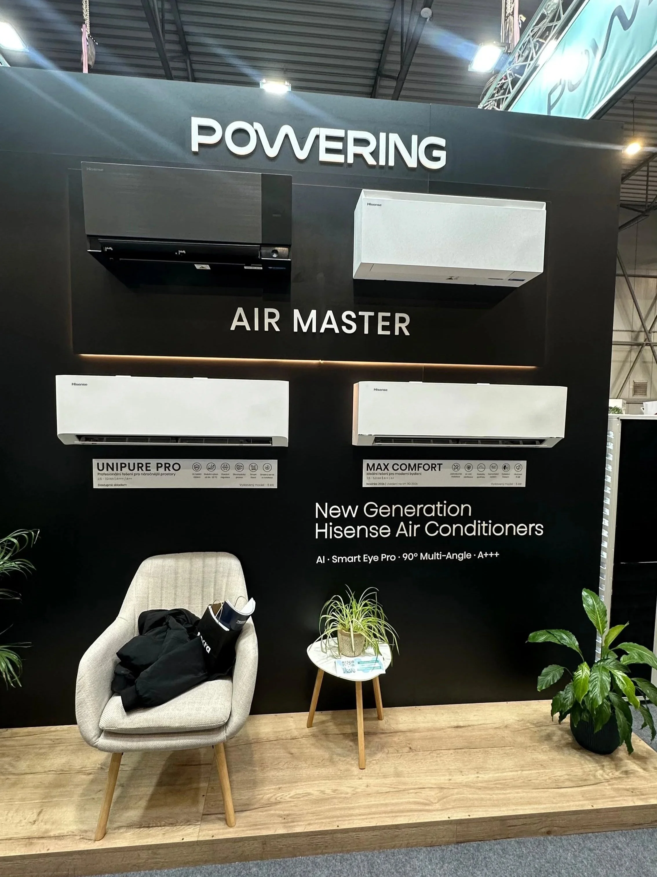 Výstavná prezentácia klimatizácií Hisense s tromi nástennými jednotkami umiestnenými na čiernej stene s označením „Powering Air Master“. Dve biele jednotky nesú označenia „UNIPURE PRO“ a „MAX COMFORT“.