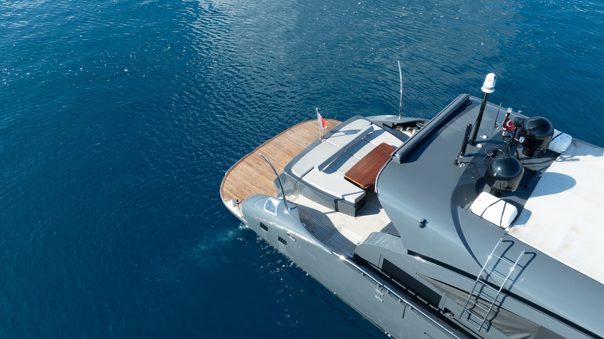 Aerial view of a luxury yacht sailing in blue water, showcasing Over Oceans Yacht Interiors Projects & Management.