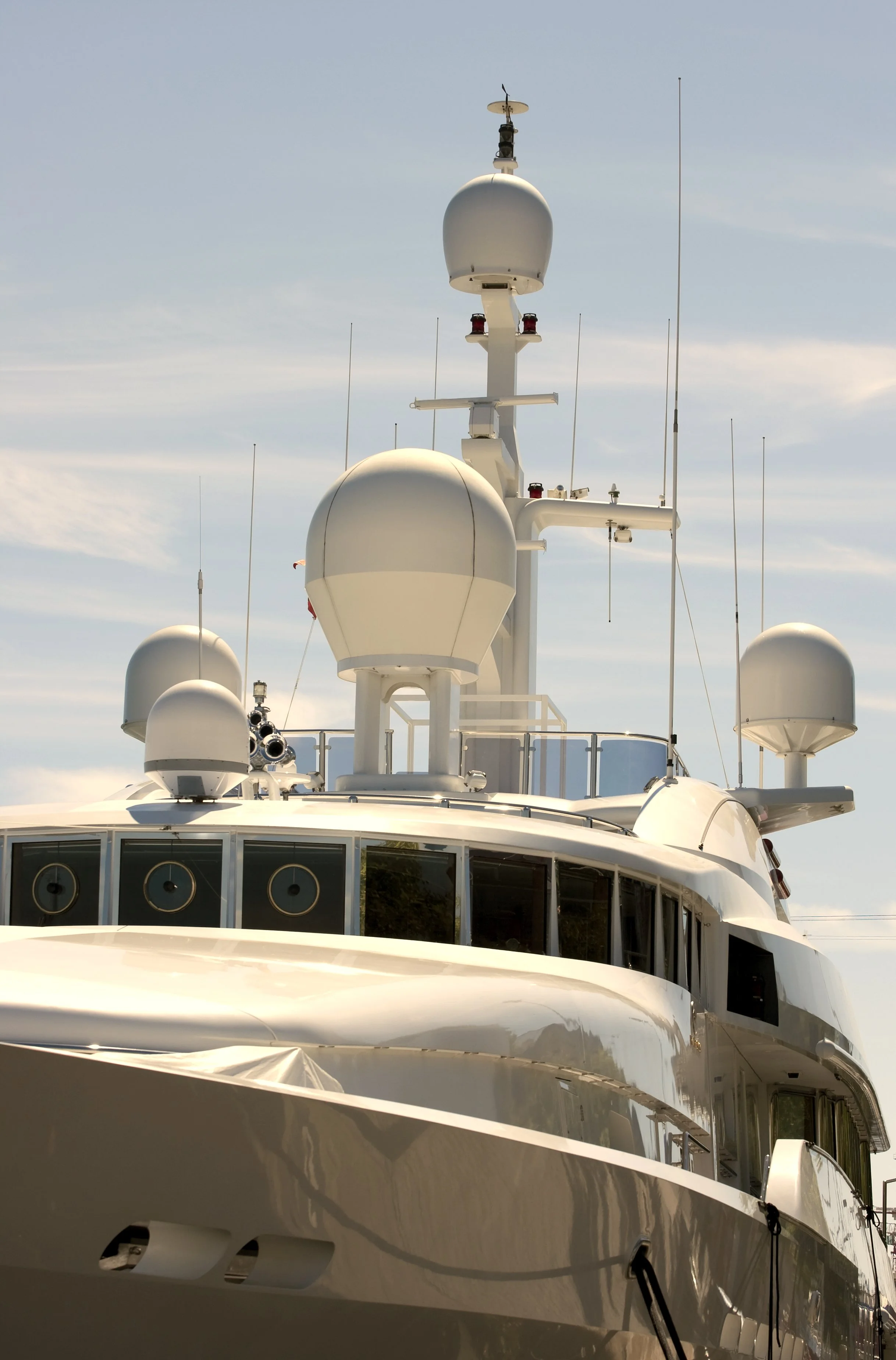 Close-up of a yacht’s radar and communication antennas against a blue sky, showcasing Over Oceans Yacht Interiors Projects & Management