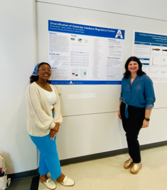 Two women standing next to a research poster in a conference or academic setting.