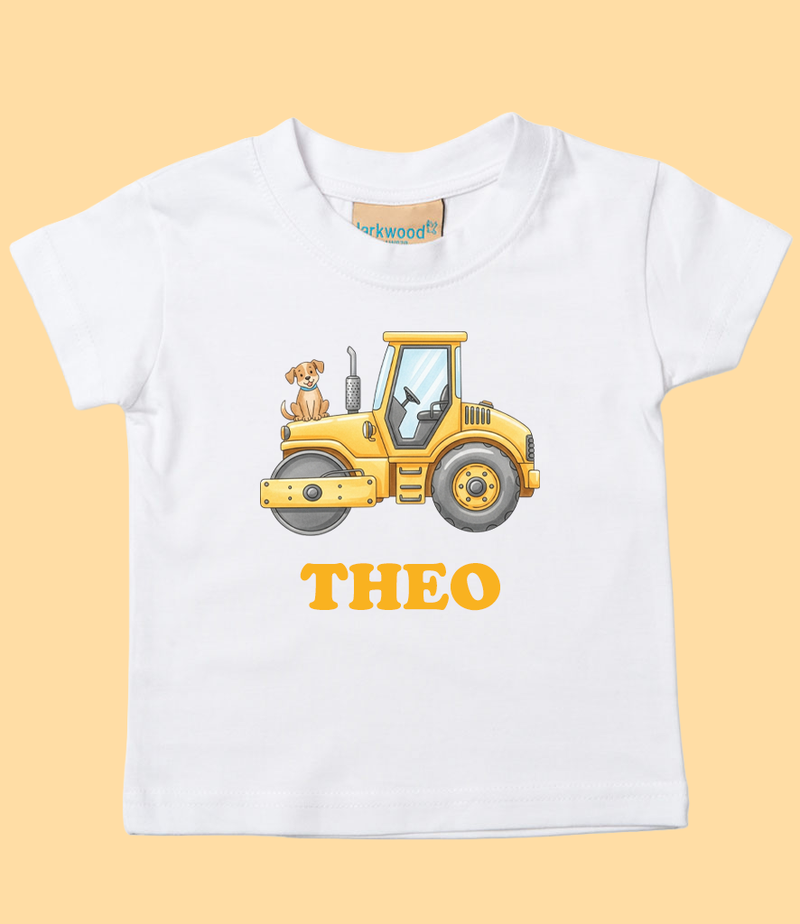 A white children's T-shirt with a graphic of a yellow construction vehicle, a small brown and white puppy sitting on top, and the name "THEO" in orange below the illustration.