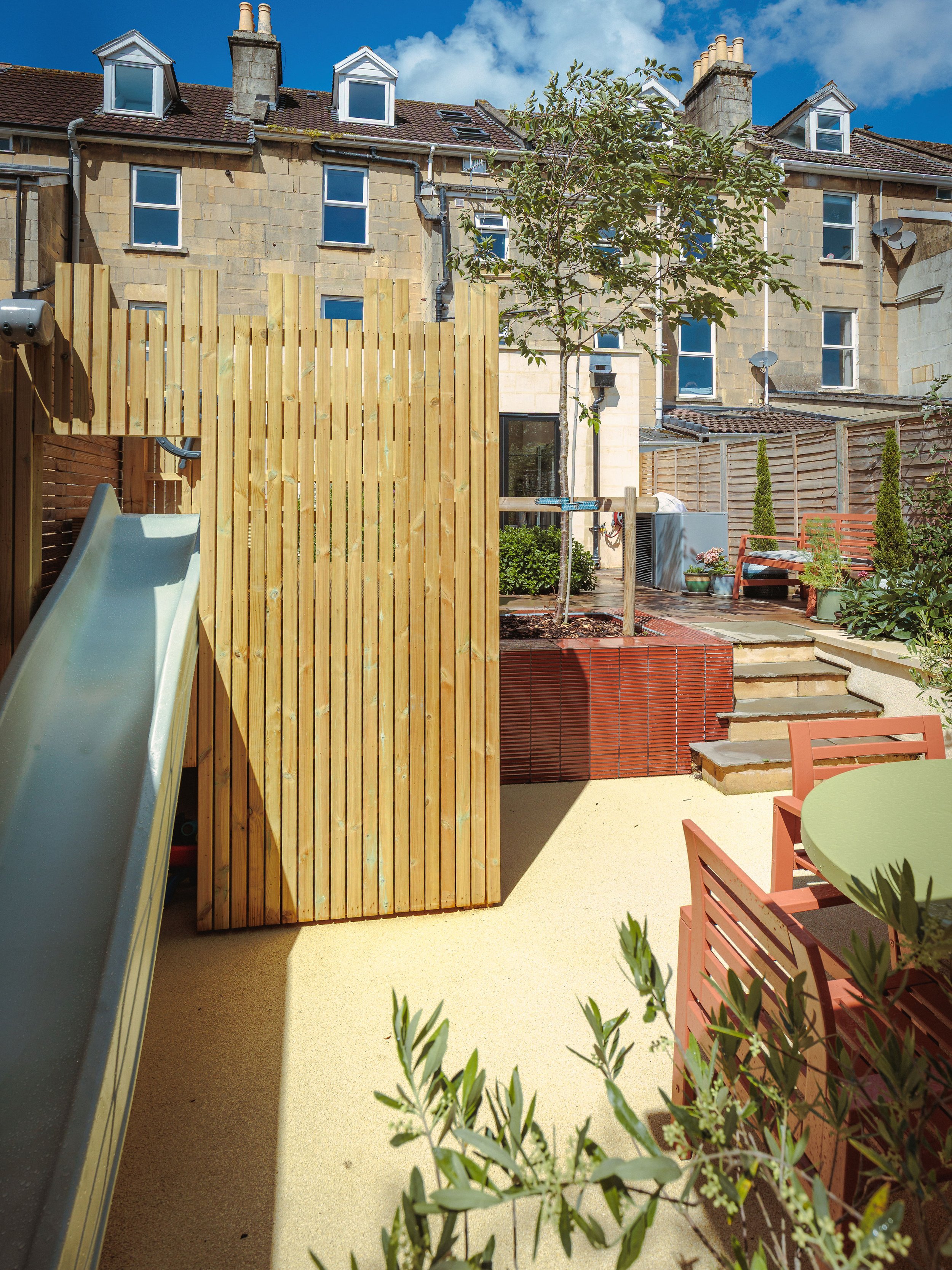 Climbing frame with slide leading to outdoor dining area