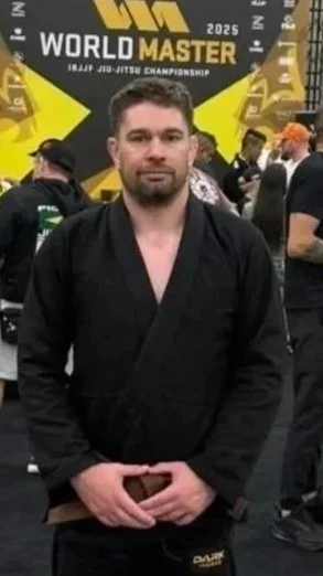 Man in a black judo gi at the 2025 World Jiu-Jitsu Championship, standing in a crowded event space.