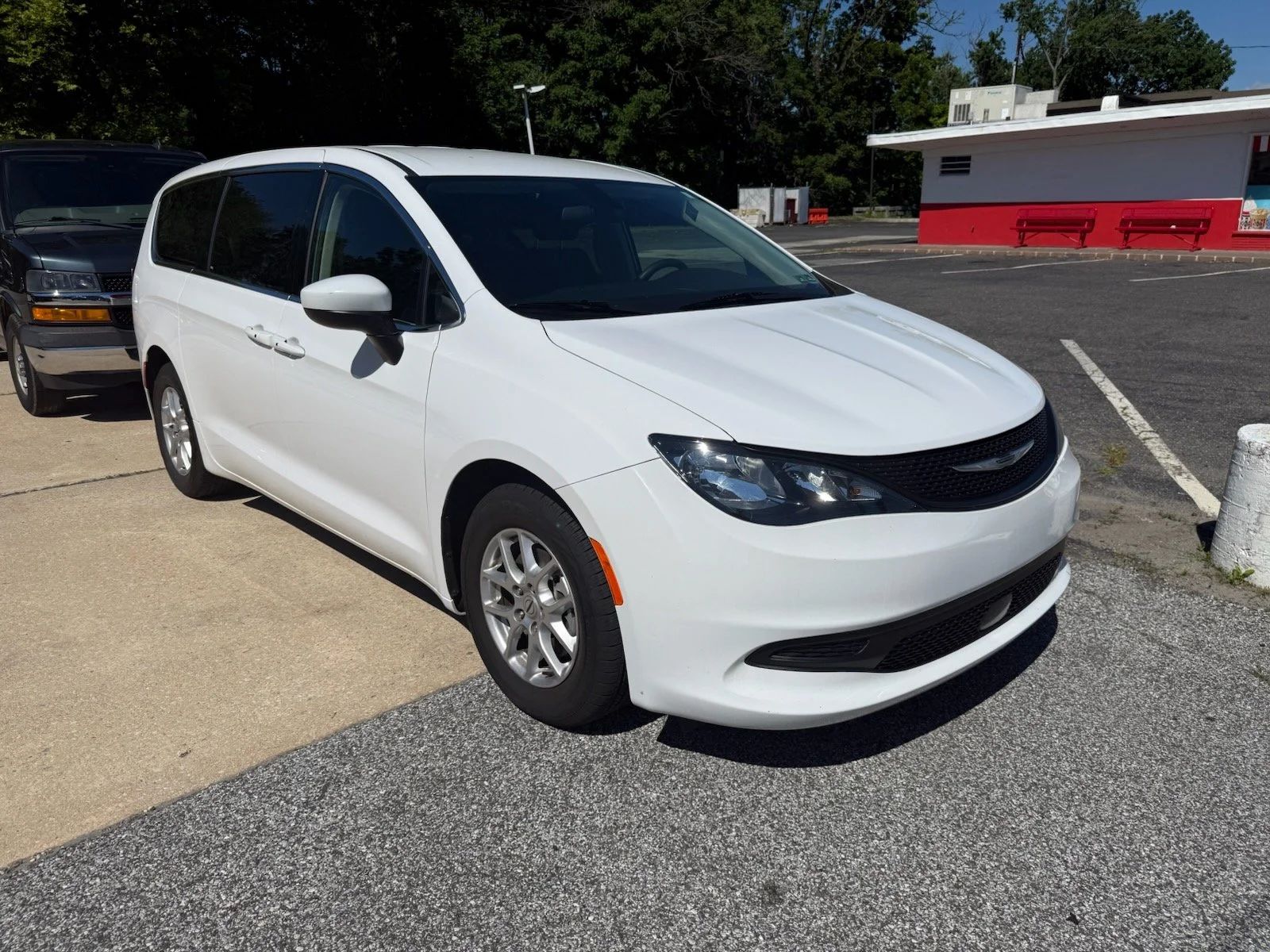 A white Chrysler minivan parked in a parking lot.