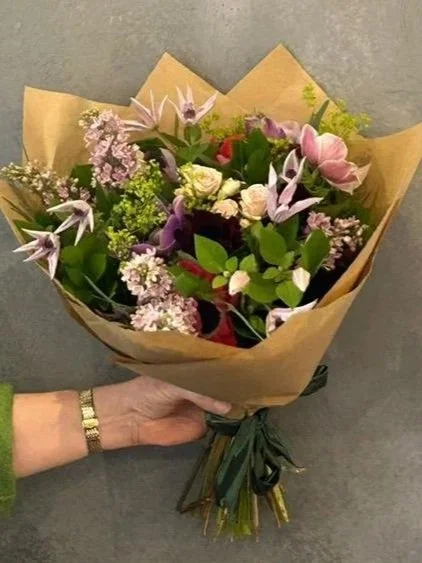 Gift bouquet with Lilac, Clematis, and Spray Roses wrapped in craft brown paper