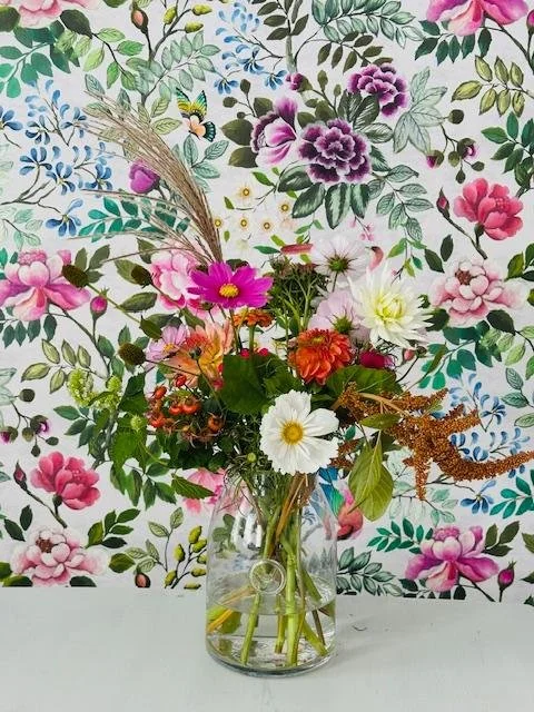 Seasonal pastel colour flowers in a glass vase