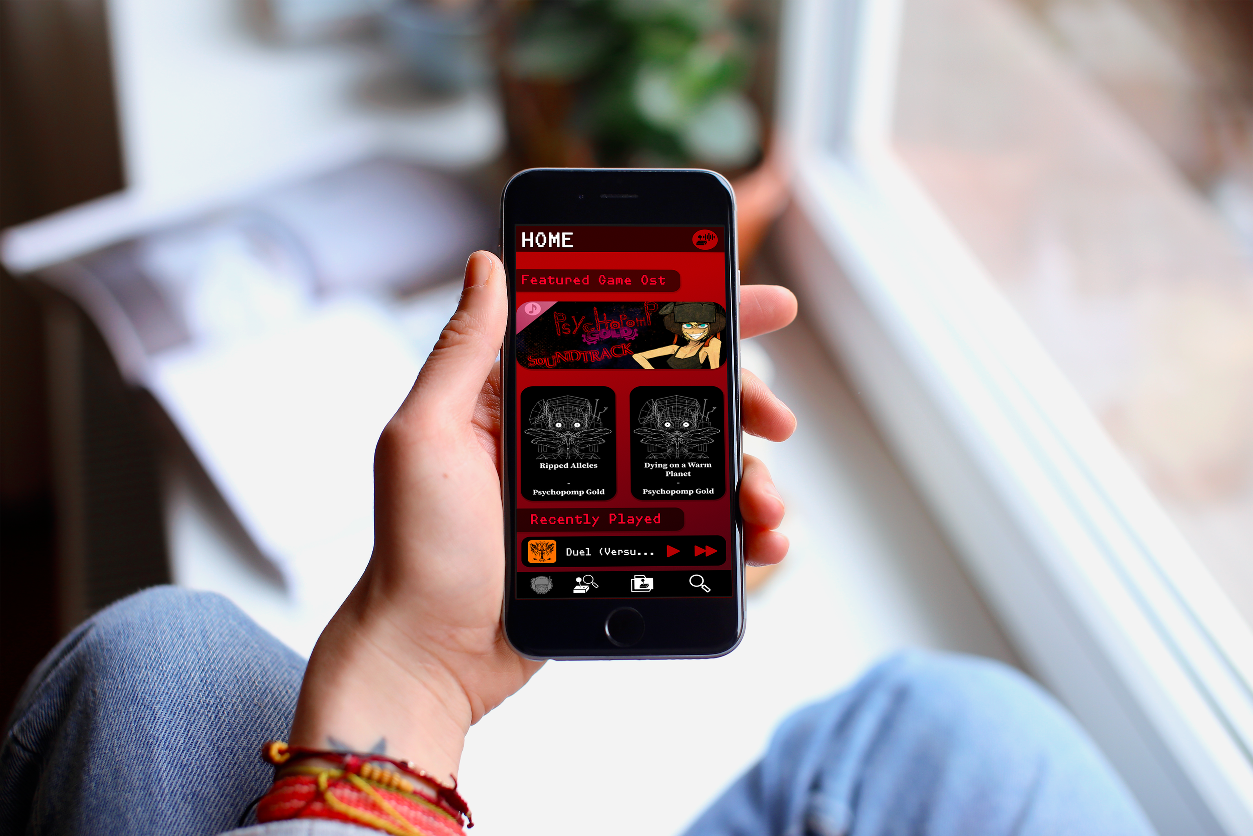 Person holding a mobile phone with a red-themed game app open on the screen, featuring game titles and icons, sitting near a window with natural light.