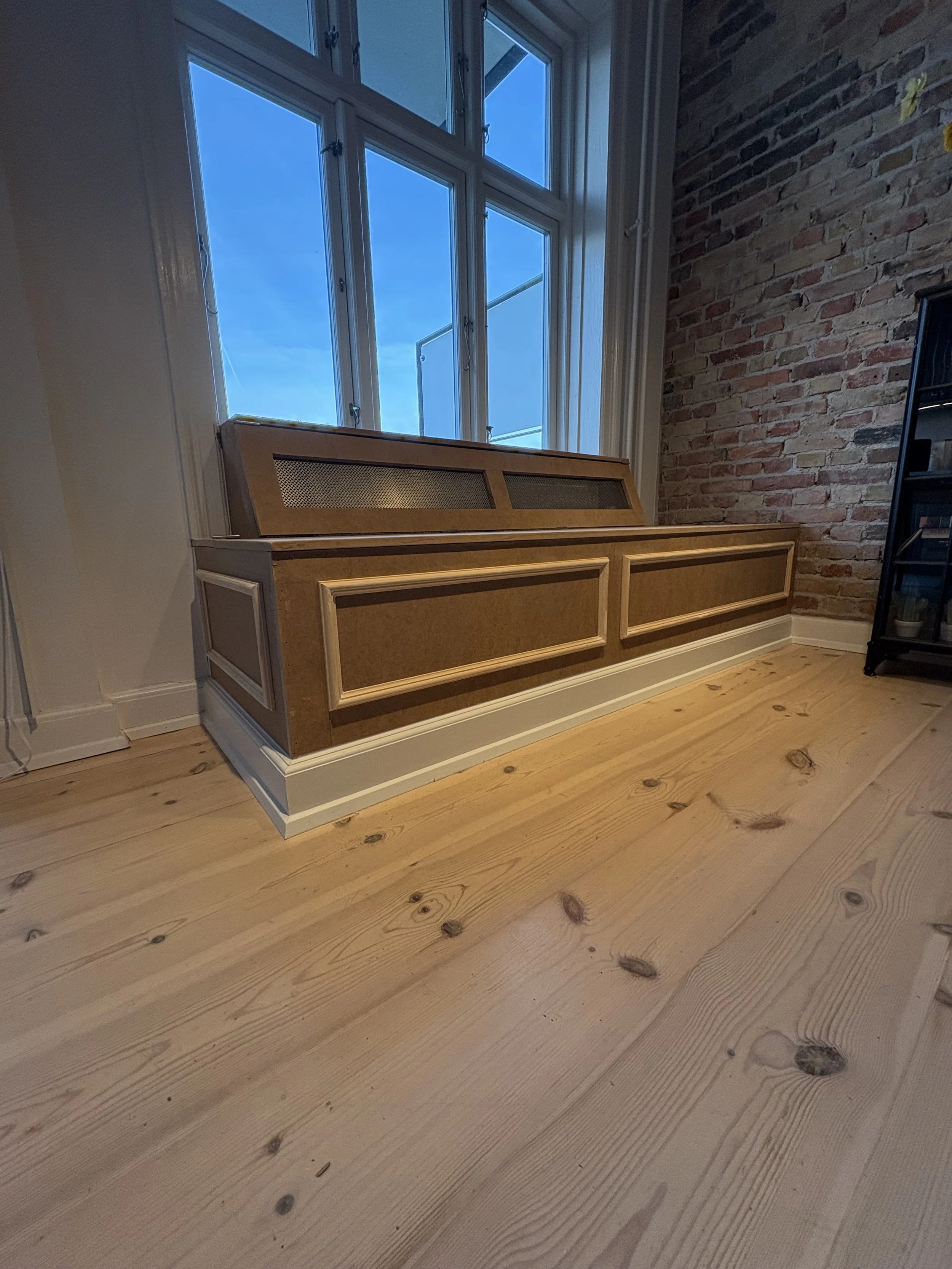 Radiatorskjuler kombineret med bænk og indbygget opbevaring udført på Frederiksberg. Funktionel og pladsbesparende løsning i snedkerkvalitet med fokus på design, komfort og holdbarhed.