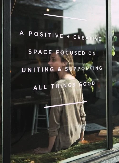 woman sitting in window of coffee shop
