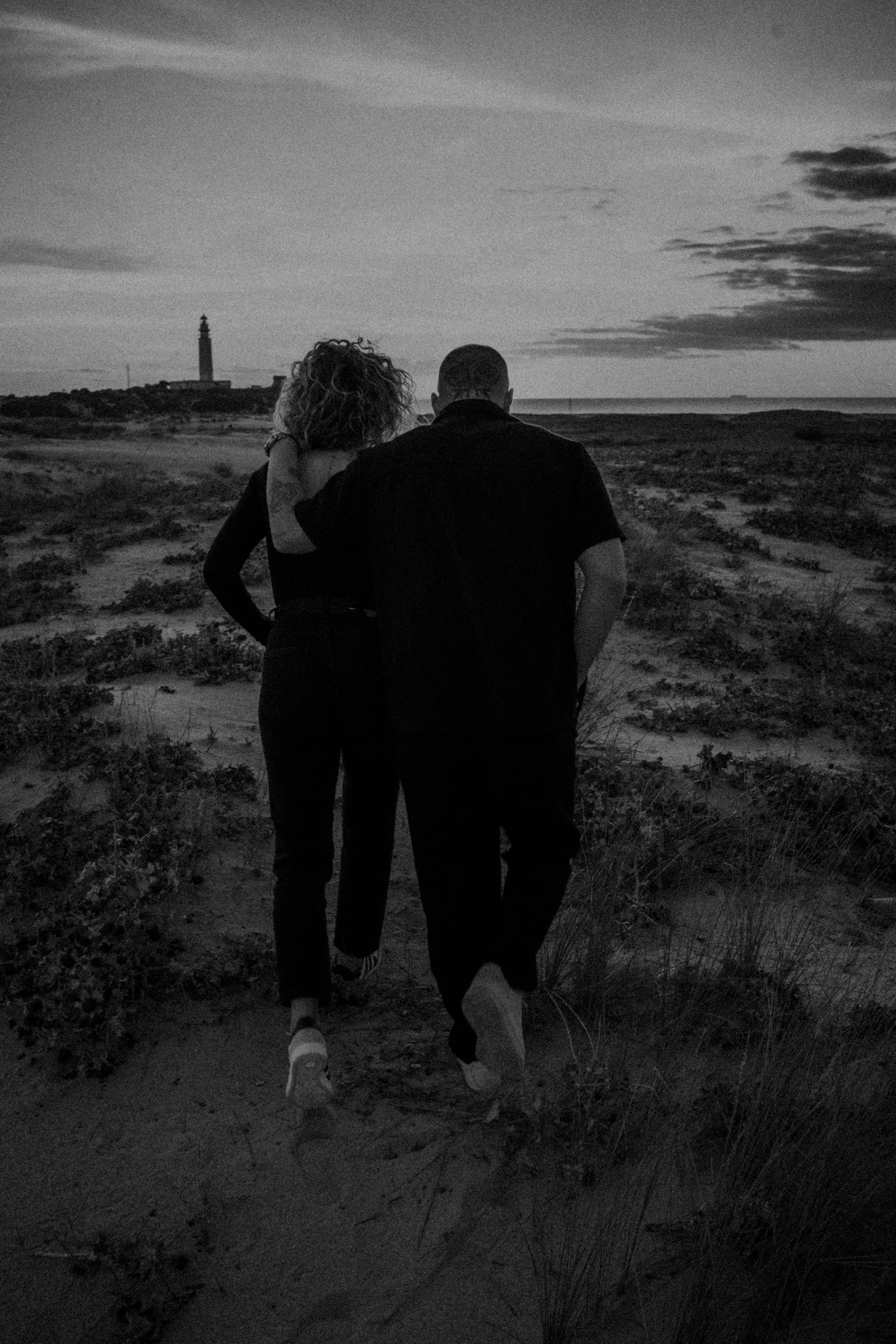 Pareja caminando por la playa en Cádiz al atardecer preboda