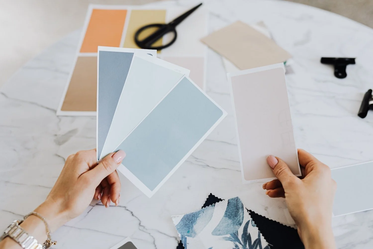 Femme tenant des échantillon de couleur dans la main pour choisir la tonalité parfaite pour la décoration d'une pièce