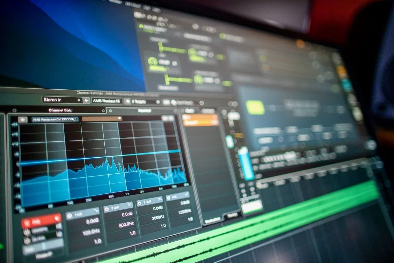 A digital audio mixing and editing software on a computer screen with spectral analysis, equalizer settings, and waveforms.