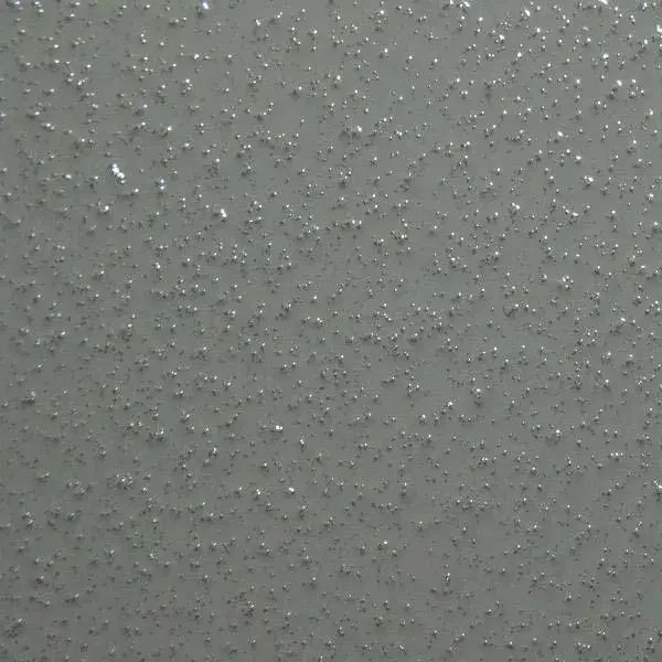 Close-up of a textured ceiling with small, shiny, metallic or glittering spots scattered across the surface.