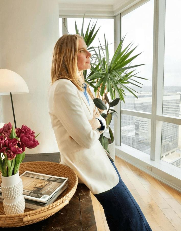 eating disorder therapist Jennifer Warpool in a blazer, arms crossed looking out the window pensively