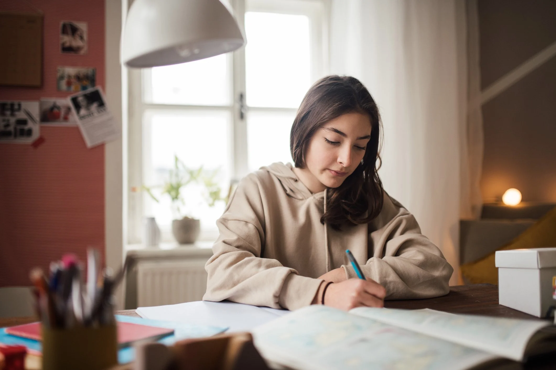 A teen girl studying at a desk at home