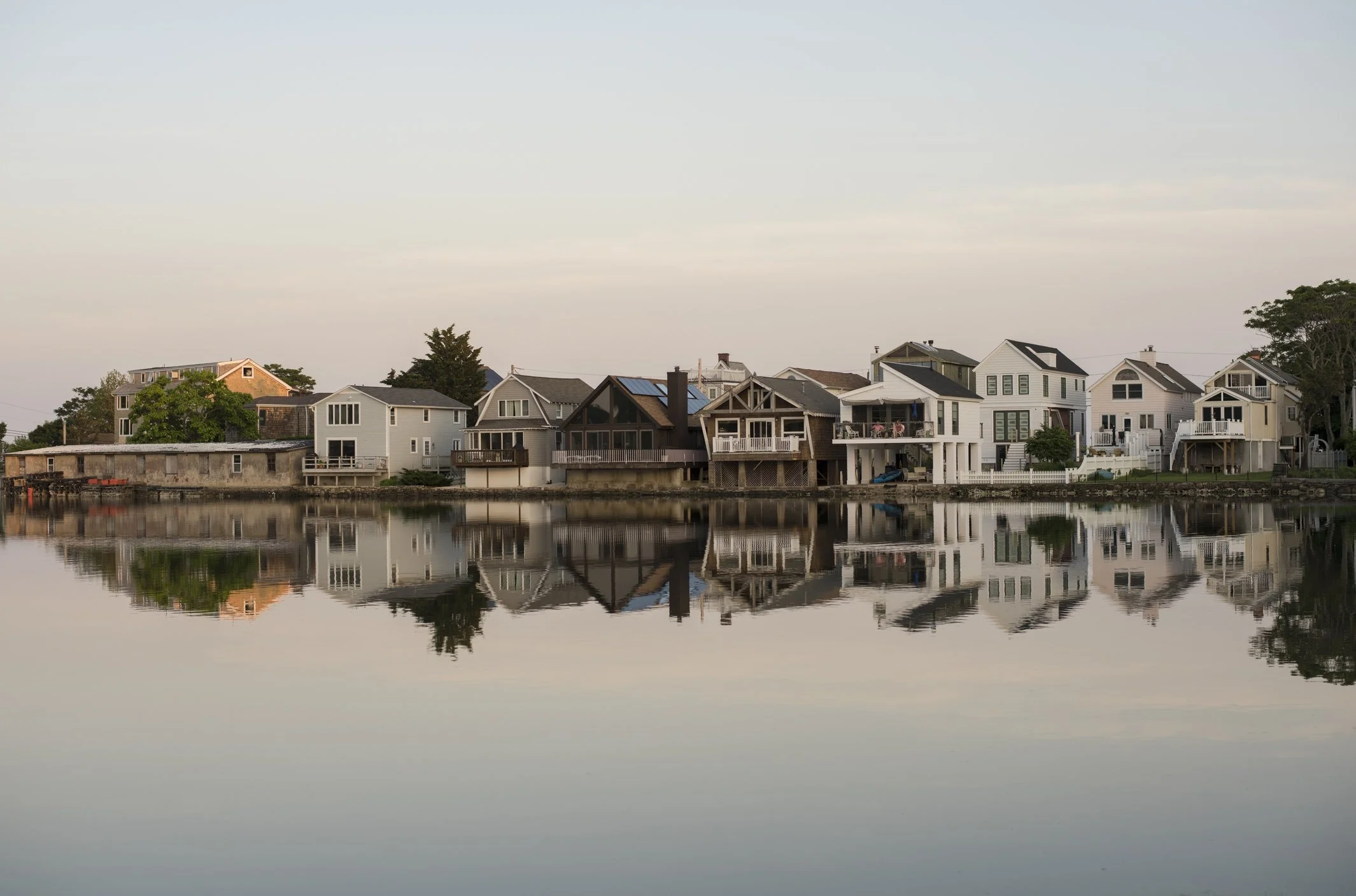 A row of waterfront houses with their reflections on the water