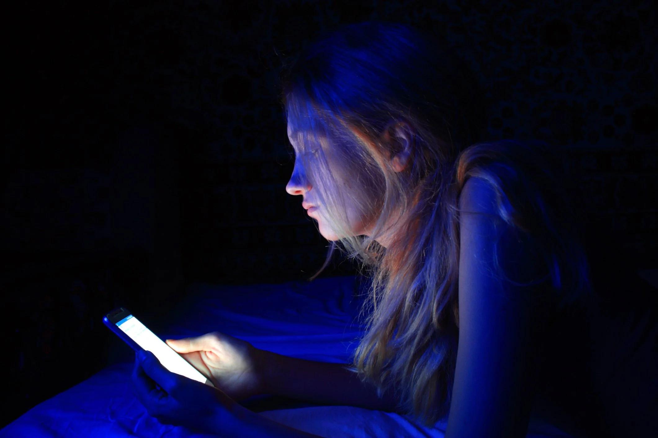 Teenage girl on phone in the middle of the night