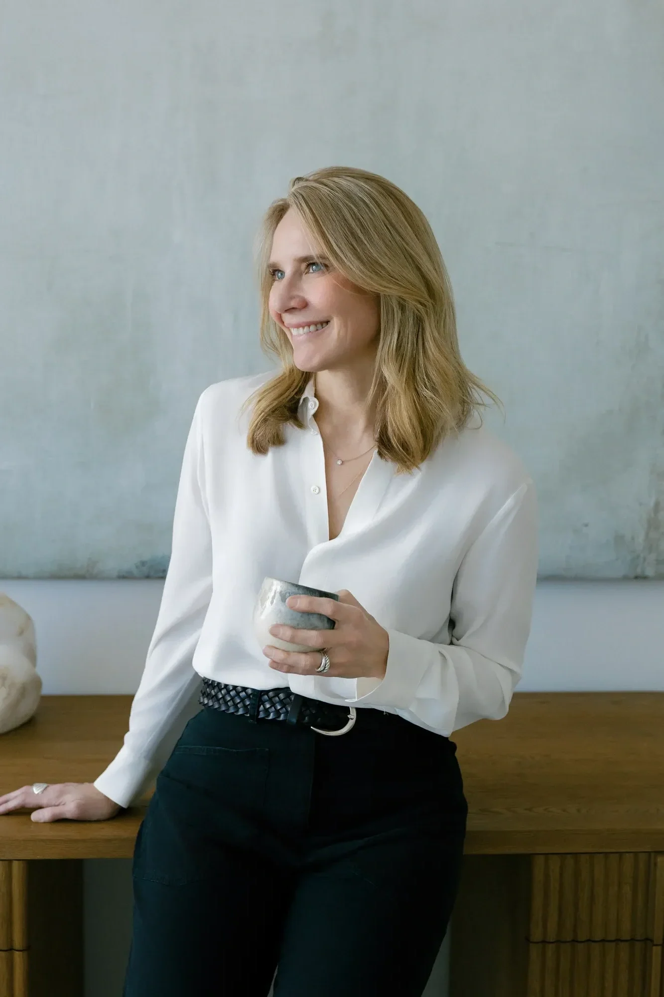 Jennifer Warpool, a therapist in the Westchester County NY area, smiles holding a mug