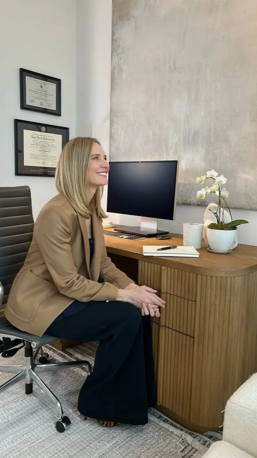 Therapist Jennifer Warpool smiling at her desk